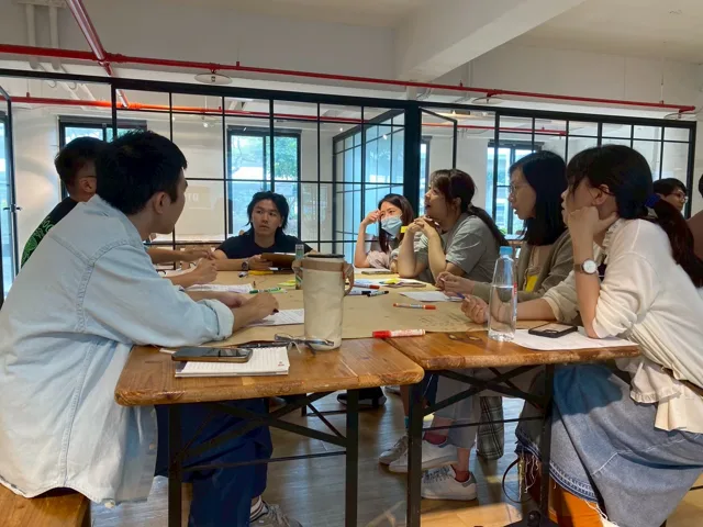 工作坊學員圍著桌子分組討論